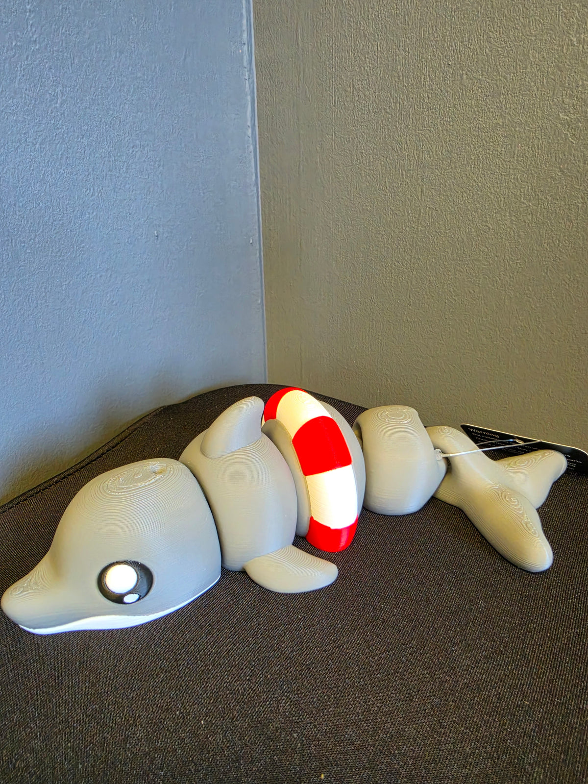 Articulated grey dolphin toy with a red and white life ring by FAN3DP